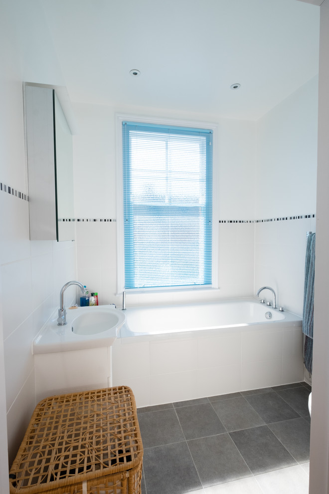 Ispirazione per una piccola stanza da bagno per bambini contemporanea con piastrelle bianche, pareti bianche, pavimento in pietra calcarea, lavabo da incasso e pavimento grigio