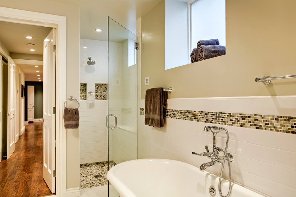 На фото: главная ванная комната среднего размера в стиле неоклассика (современная классика) с отдельно стоящей ванной, душем в нише, белой плиткой, керамической плиткой и бежевыми стенами