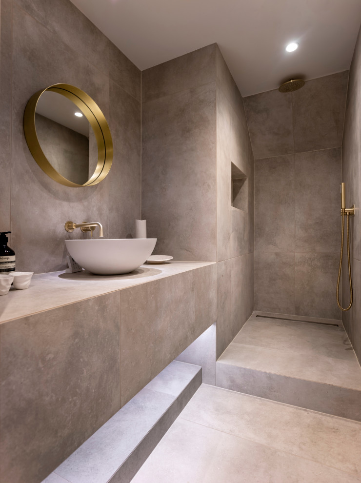 Inspiration för stora moderna grått en-suite badrum, med släta luckor, grå skåp, ett fristående badkar, en öppen dusch, en vägghängd toalettstol, grå kakel, keramikplattor, grå väggar, cementgolv, ett avlångt handfat, kaklad bänkskiva, grått golv och med dusch som är öppen