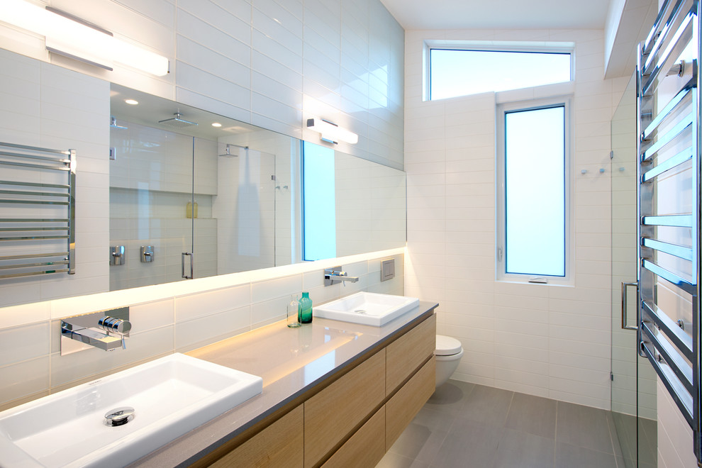 Idées déco pour une salle de bain moderne en bois clair avec un placard à porte plane, un plan de toilette en quartz, une douche double, WC suspendus, des carreaux de porcelaine, un mur blanc, un sol en carrelage de porcelaine et un carrelage blanc.