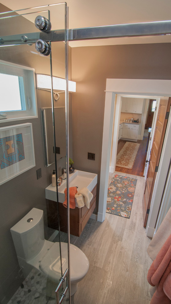 Immagine di una piccola stanza da bagno con doccia stile americano con doccia a filo pavimento, piastrelle di ciottoli, pareti marroni e lavabo rettangolare