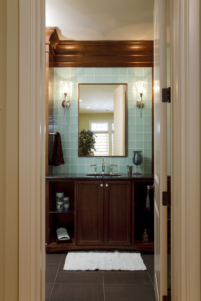 Modelo de cuarto de baño tradicional con armarios con paneles empotrados, puertas de armario de madera en tonos medios y baldosas y/o azulejos azules