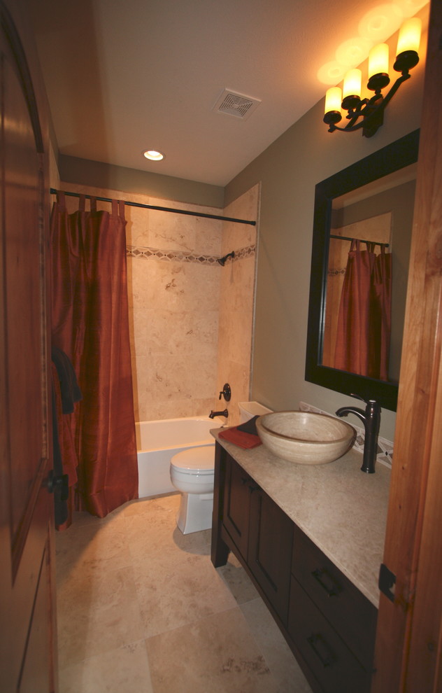 This is an example of a small traditional bathroom in Seattle with a vessel sink, shaker cabinets, dark wood cabinets, marble worktops, an alcove bath, a one-piece toilet, beige tiles, stone tiles, brown walls and marble flooring.
