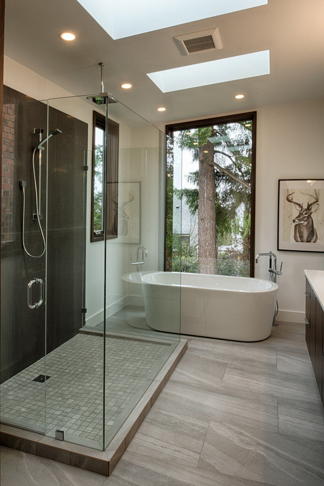 Large contemporary ensuite bathroom in Seattle with flat-panel cabinets, dark wood cabinets, a freestanding bath, a walk-in shower, a two-piece toilet, grey tiles, porcelain tiles, white walls, ceramic flooring, a vessel sink and engineered stone worktops.