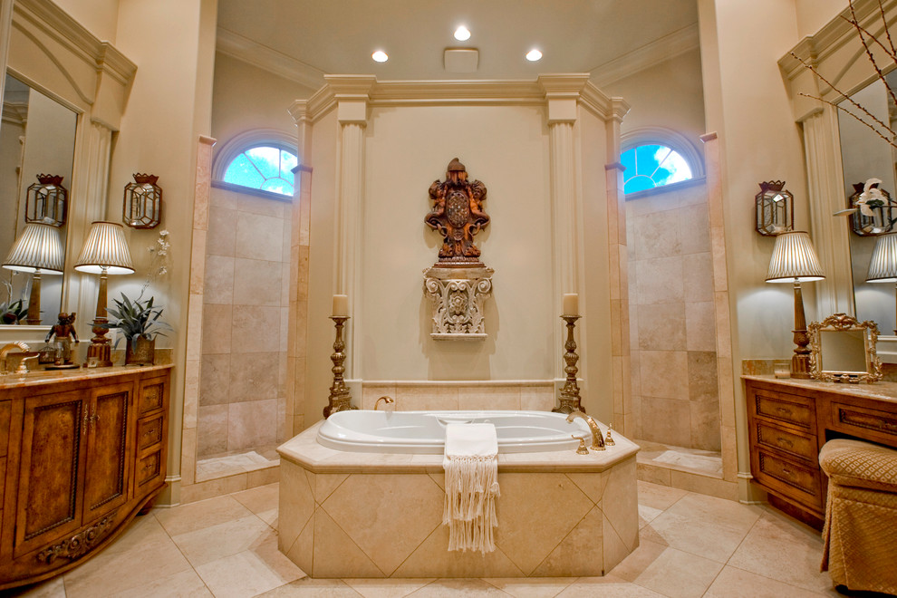 На фото: ванная комната в средиземноморском стиле с фасадами цвета дерева среднего тона, накладной ванной, бежевой плиткой и фасадами с утопленной филенкой