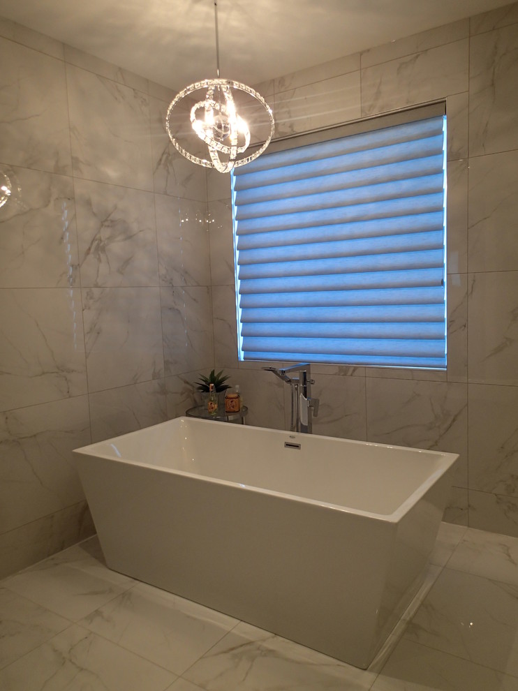 Ejemplo de cuarto de baño principal tradicional con bañera exenta, baldosas y/o azulejos blancos, paredes blancas y suelo de baldosas de porcelana