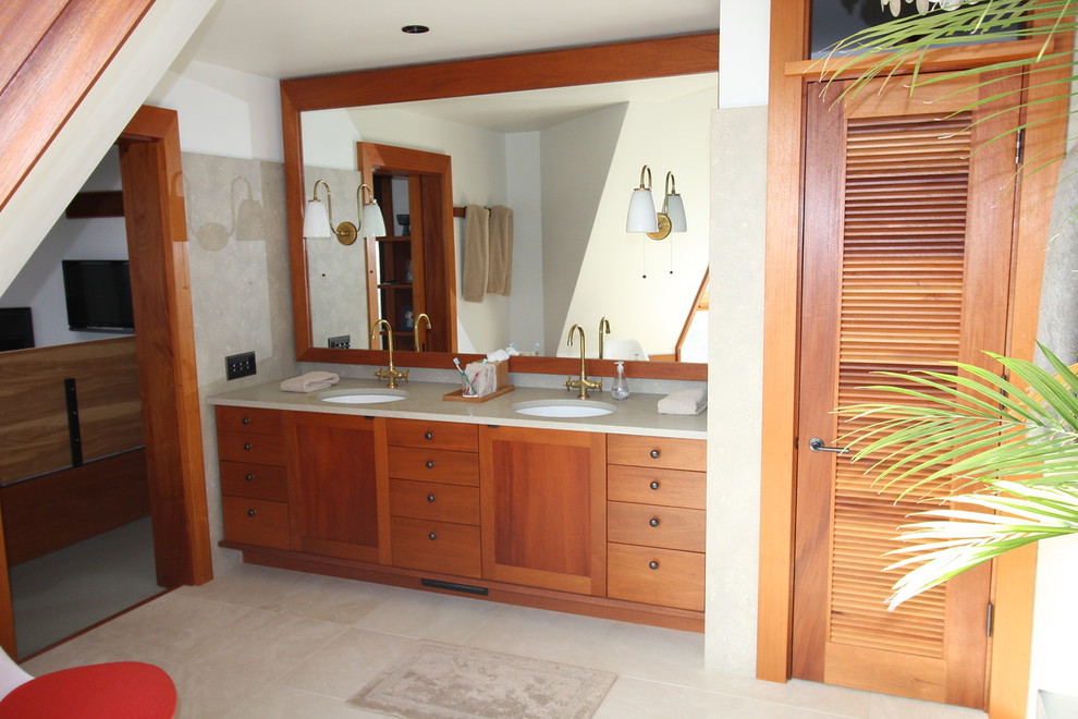 Diseño de cuarto de baño principal exótico de tamaño medio con armarios con paneles lisos, puertas de armario de madera oscura, suelo de travertino, lavabo bajoencimera y suelo beige