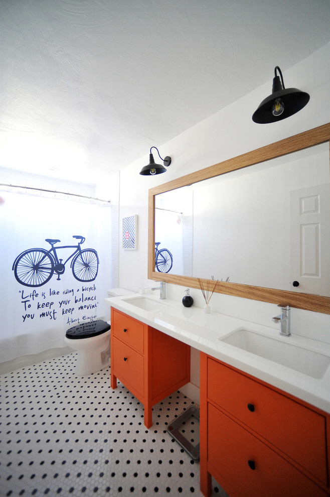 Стильный дизайн: ванная комната среднего размера в стиле ретро с врезной раковиной, плоскими фасадами, оранжевыми фасадами, стеклянной столешницей, душем над ванной, черно-белой плиткой, белыми стенами и полом из мозаичной плитки - последний тренд