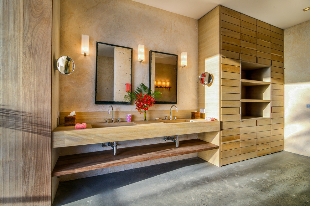 Exotisk inredning av ett beige beige en-suite badrum, med öppna hyllor, beige väggar, betonggolv, ett integrerad handfat och grått golv