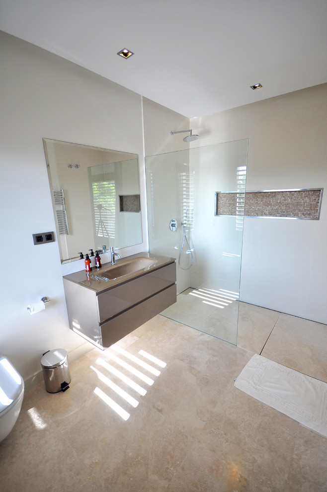 Foto di una grande stanza da bagno con doccia design con ante lisce, ante beige, doccia a filo pavimento, WC monopezzo, pareti beige e lavabo integrato