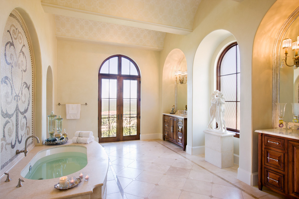 На фото: ванная комната в классическом стиле с фасадами с выступающей филенкой, темными деревянными фасадами, полновстраиваемой ванной и бежевой плиткой с