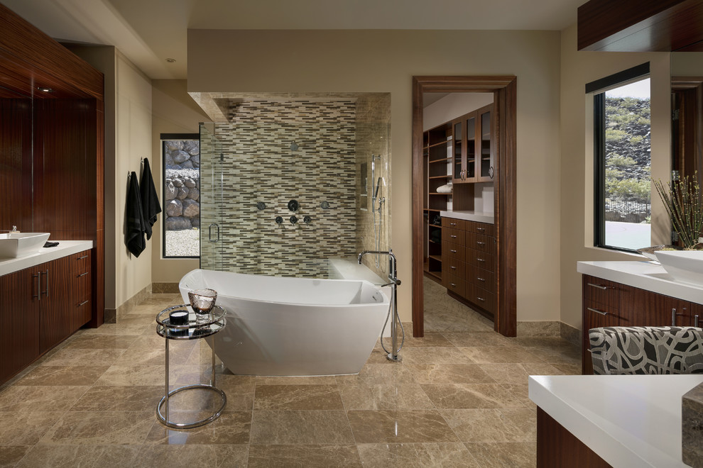 Cette photo montre une salle de bain sud-ouest américain en bois foncé avec un placard à porte plane, une baignoire indépendante, un mur beige, une vasque, un sol marron, une cabine de douche à porte battante et un plan de toilette blanc.