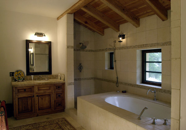 Inredning av ett medelhavsstil stort en-suite badrum, med ett undermonterad handfat, luckor med upphöjd panel, skåp i mellenmörkt trä, granitbänkskiva, ett undermonterat badkar, en hörndusch, en toalettstol med hel cisternkåpa, beige kakel, stenkakel, beige väggar och travertin golv