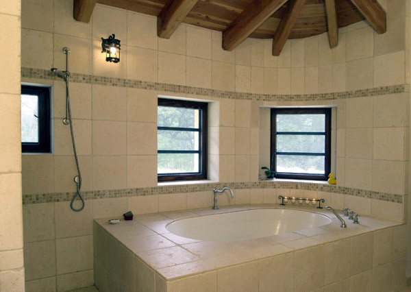 Idéer för att renovera ett stort medelhavsstil en-suite badrum, med ett undermonterad handfat, luckor med upphöjd panel, skåp i mellenmörkt trä, granitbänkskiva, ett undermonterat badkar, en hörndusch, en toalettstol med hel cisternkåpa, beige kakel, stenkakel, beige väggar och travertin golv