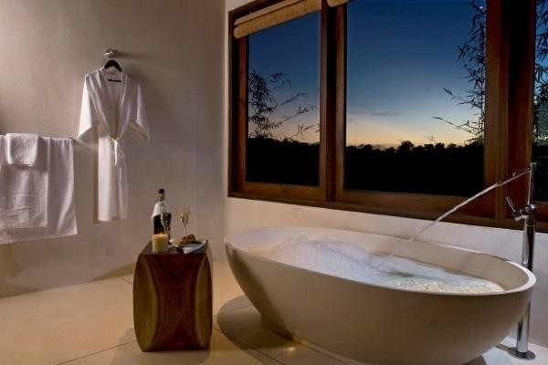 Foto på ett stort tropiskt badrum, med ett fristående badkar