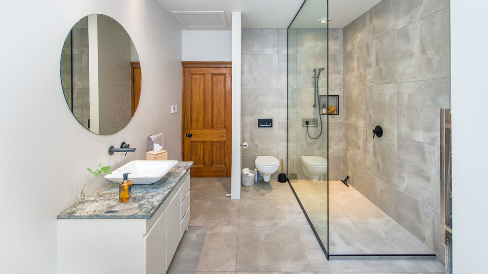 Immagine di una stanza da bagno contemporanea di medie dimensioni con doccia ad angolo, WC sospeso, top in marmo e porta doccia scorrevole
