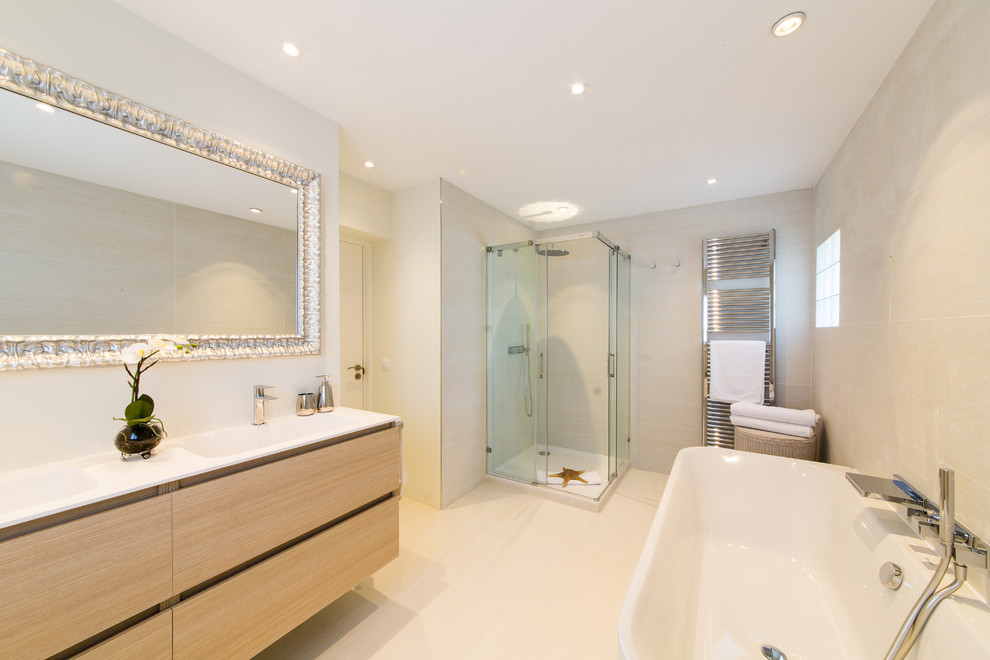 Imagen de cuarto de baño principal escandinavo grande con armarios con paneles lisos, puertas de armario de madera clara, bañera empotrada, ducha esquinera, paredes beige y lavabo integrado
