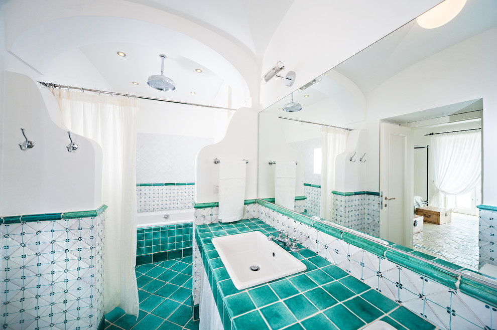 Пример оригинального дизайна: большая ванная комната в средиземноморском стиле с накладной раковиной, столешницей из плитки, ванной в нише, открытым душем, зеленой плиткой, керамической плиткой, белыми стенами, полом из керамической плитки и шторкой для ванной