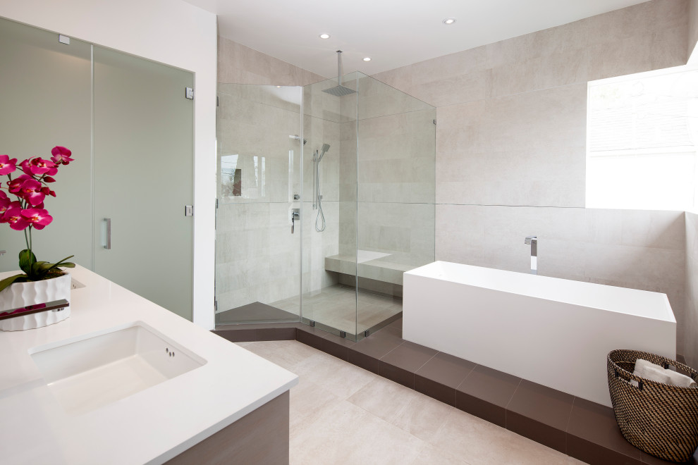 Imagen de cuarto de baño minimalista con bañera exenta, baldosas y/o azulejos grises, lavabo bajoencimera, suelo gris y encimeras blancas