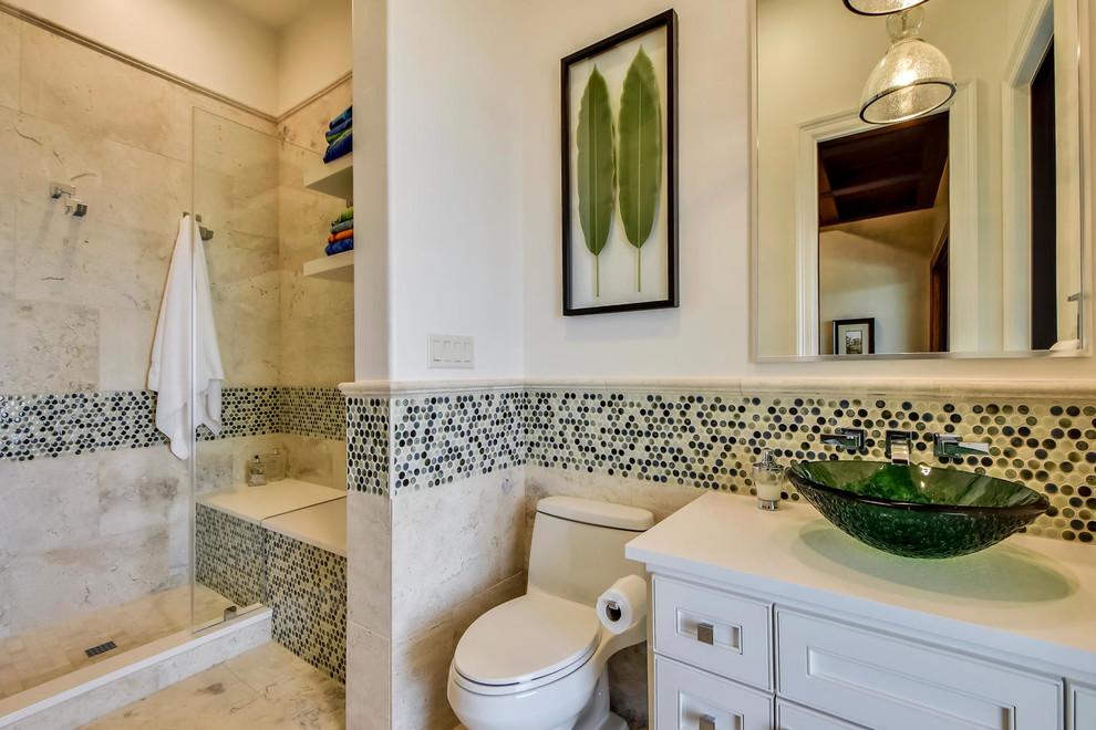 This is an example of a large mediterranean family bathroom in Austin with shaker cabinets, white cabinets, a double shower, a one-piece toilet, beige tiles, stone tiles, white walls, travertine flooring, a vessel sink and marble worktops.