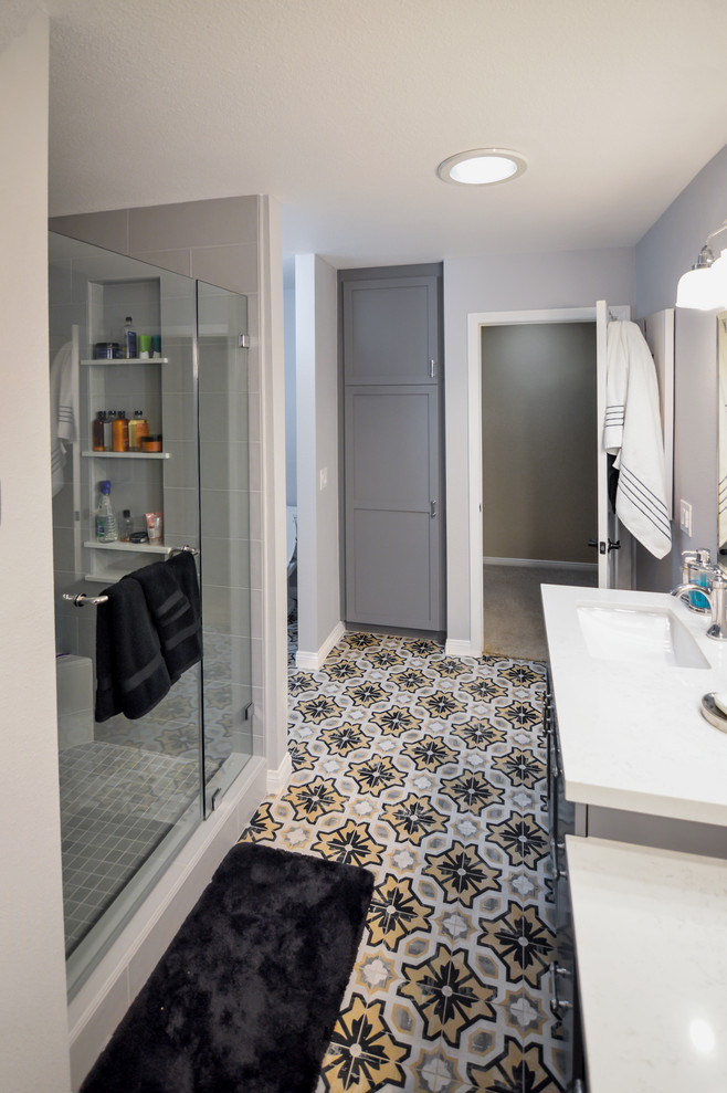Photo of a medium sized contemporary shower room bathroom with recessed-panel cabinets, grey cabinets, a built-in bath, an alcove shower, grey tiles, porcelain tiles, white walls, a console sink, quartz worktops, multi-coloured floors, a hinged door, a two-piece toilet and cement flooring.