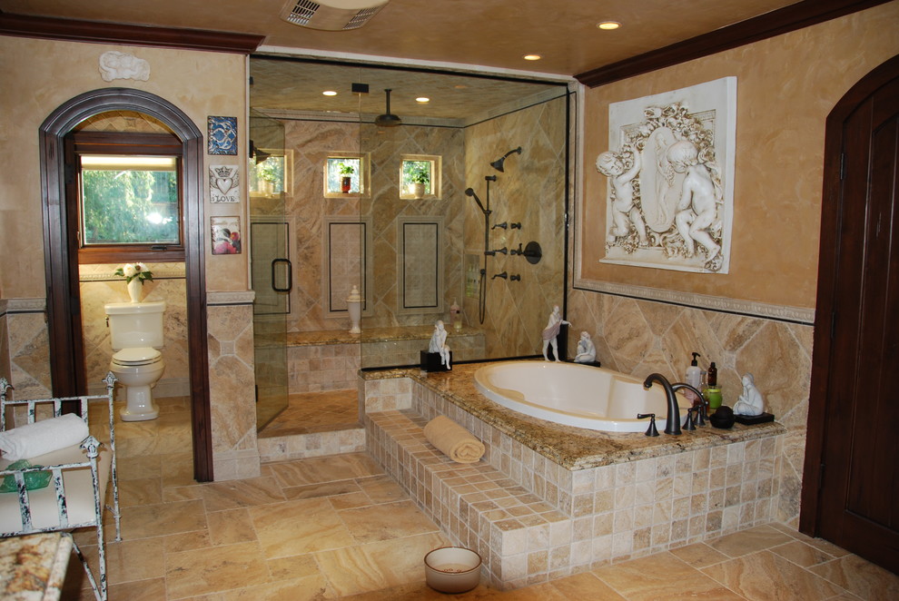 На фото: большой главный совмещенный санузел в средиземноморском стиле с накладной ванной, душем в нише, раздельным унитазом, бежевой плиткой, каменной плиткой, бежевыми стенами, полом из травертина и столешницей из гранита
