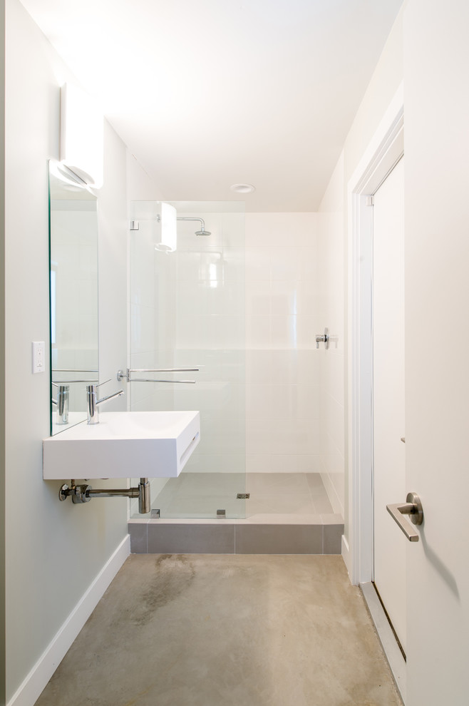 Example of a small urban 3/4 white tile and porcelain tile concrete floor alcove shower design in Orange County with a wall-mount sink, white cabinets, solid surface countertops, gray walls and furniture-like cabinets