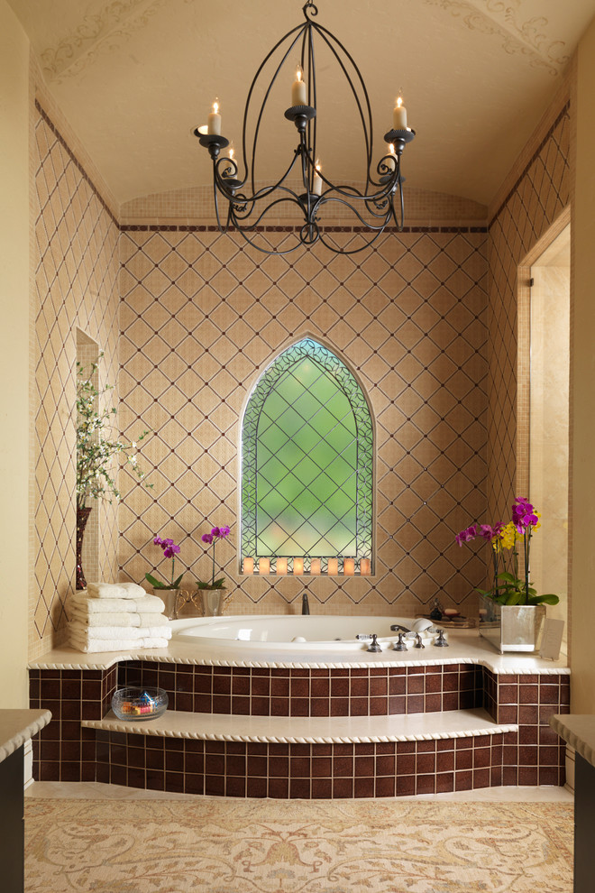 Modelo de cuarto de baño mediterráneo con bañera encastrada, baldosas y/o azulejos beige y paredes beige
