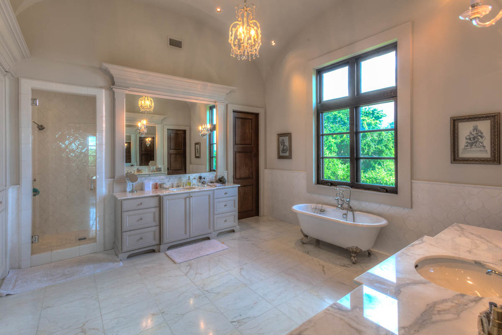 This is an example of a bathroom in Austin with grey cabinets, marble worktops, a claw-foot bath, white walls and marble flooring.
