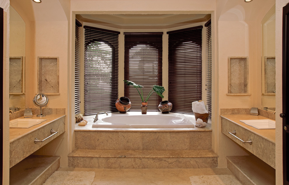 Bild på ett mellanstort medelhavsstil beige beige en-suite badrum, med öppna hyllor, ett platsbyggt badkar, ett nedsänkt handfat och granitbänkskiva