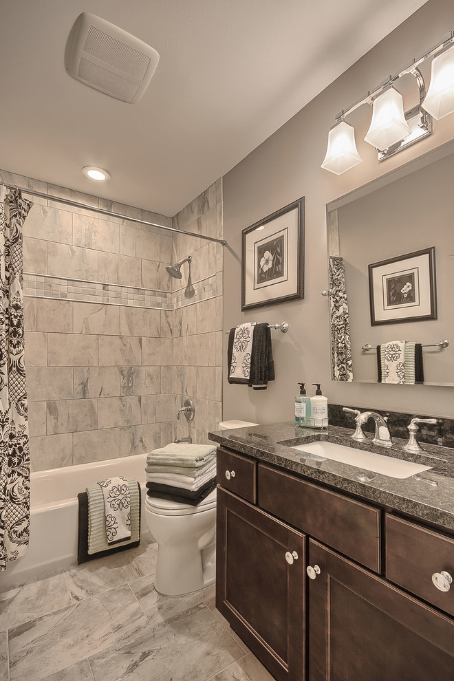 Photo of a small traditional bathroom in St Louis with a submerged sink, recessed-panel cabinets, dark wood cabinets, granite worktops, an alcove bath, a two-piece toilet, ceramic tiles and porcelain flooring.