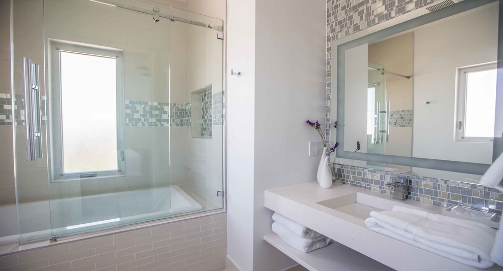 Foto de cuarto de baño costero grande con puertas de armario blancas, combinación de ducha y bañera y ducha con puerta corredera
