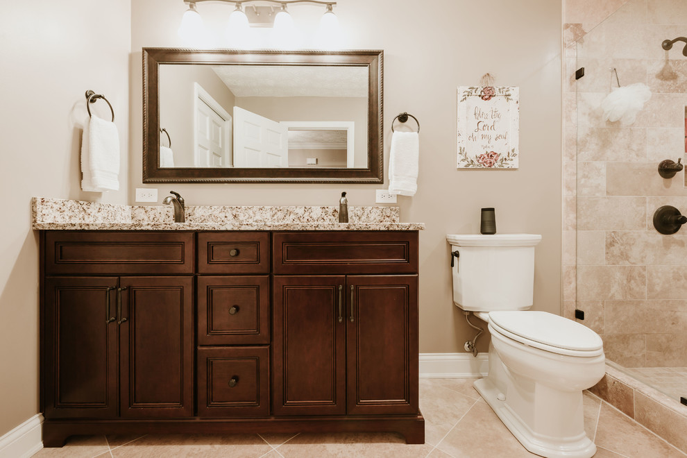 Inspiration för små klassiska brunt en-suite badrum, med luckor med infälld panel, skåp i mörkt trä, brun kakel, travertinkakel, ett undermonterad handfat och granitbänkskiva