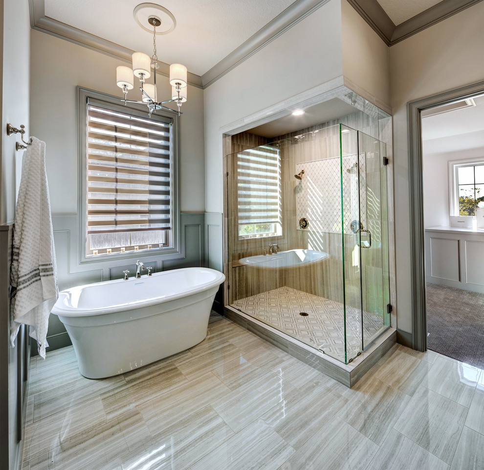 Modelo de cuarto de baño tradicional renovado con bañera exenta, ducha doble, baldosas y/o azulejos beige, paredes beige, suelo beige y ducha con puerta con bisagras