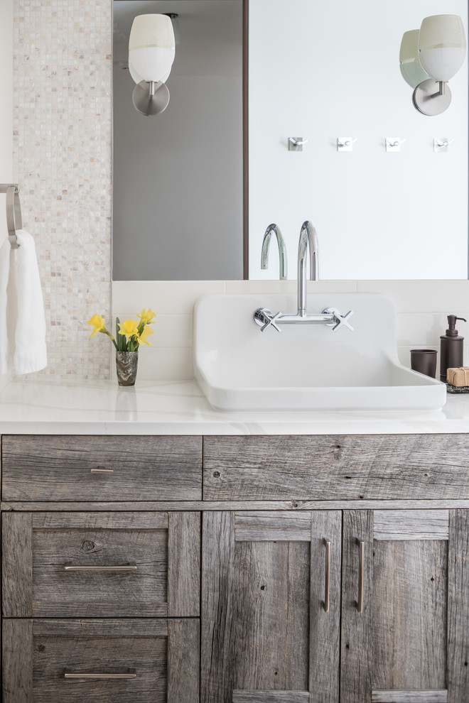 Cette image montre une salle de bain chalet en bois vieilli avec un carrelage blanc, un plan de toilette en marbre et un plan de toilette blanc.
