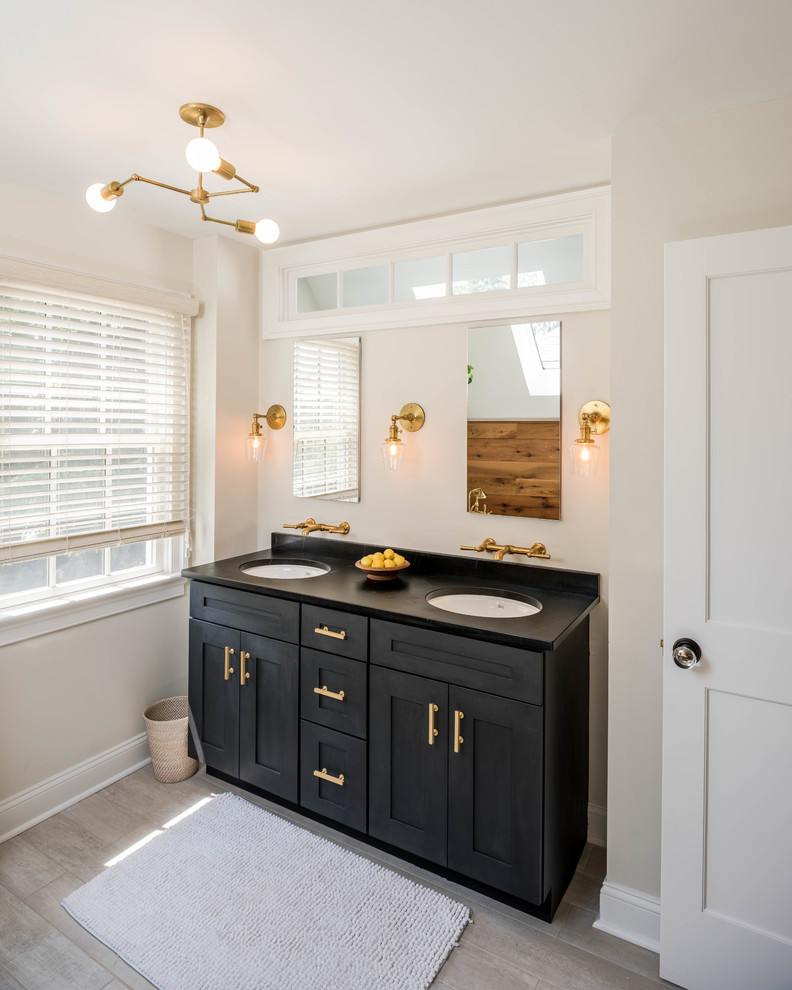 Modelo de cuarto de baño tradicional renovado con armarios estilo shaker, puertas de armario negras, paredes beige, suelo de madera clara, aseo y ducha, lavabo bajoencimera y suelo beige