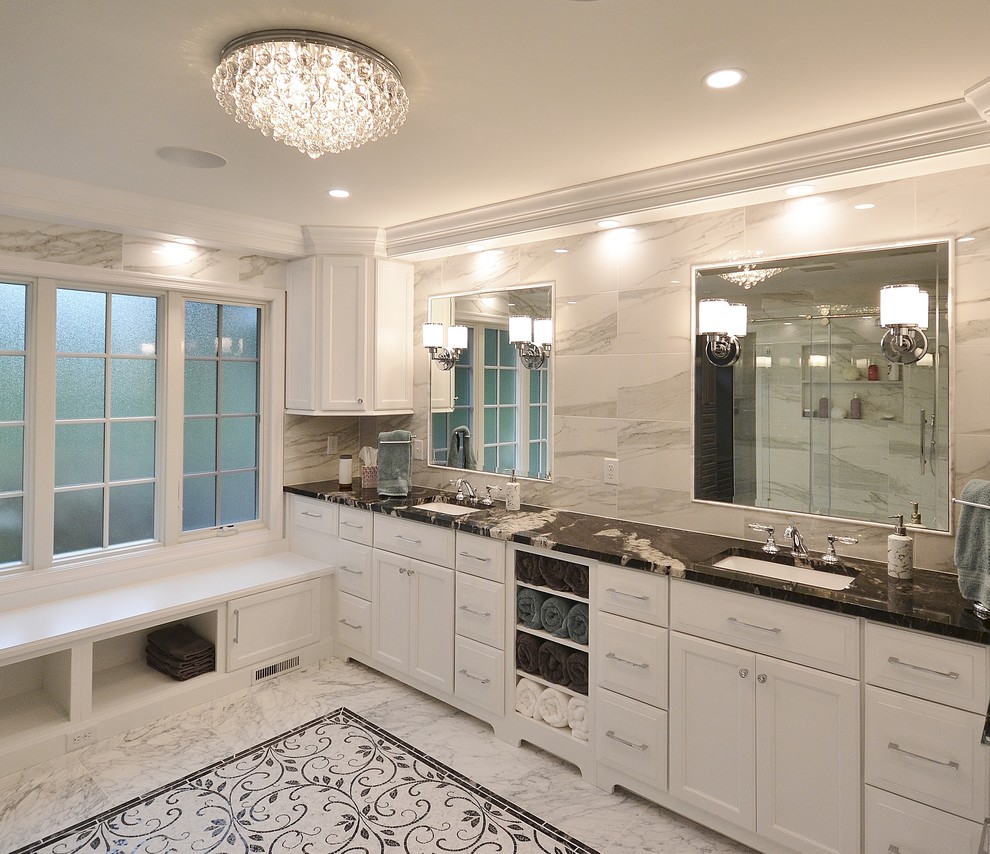 Пример оригинального дизайна: огромная главная ванная комната в стиле неоклассика (современная классика) с фасадами с утопленной филенкой, белыми фасадами, двойным душем, унитазом-моноблоком, белой плиткой, мраморной плиткой, серыми стенами, полом из винила, врезной раковиной, мраморной столешницей, белым полом, душем с раздвижными дверями и черной столешницей