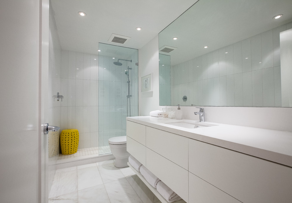 Foto di una stanza da bagno con doccia design con ante lisce, ante bianche, doccia aperta, piastrelle bianche, pareti bianche, lavabo sottopiano, pavimento bianco e doccia aperta