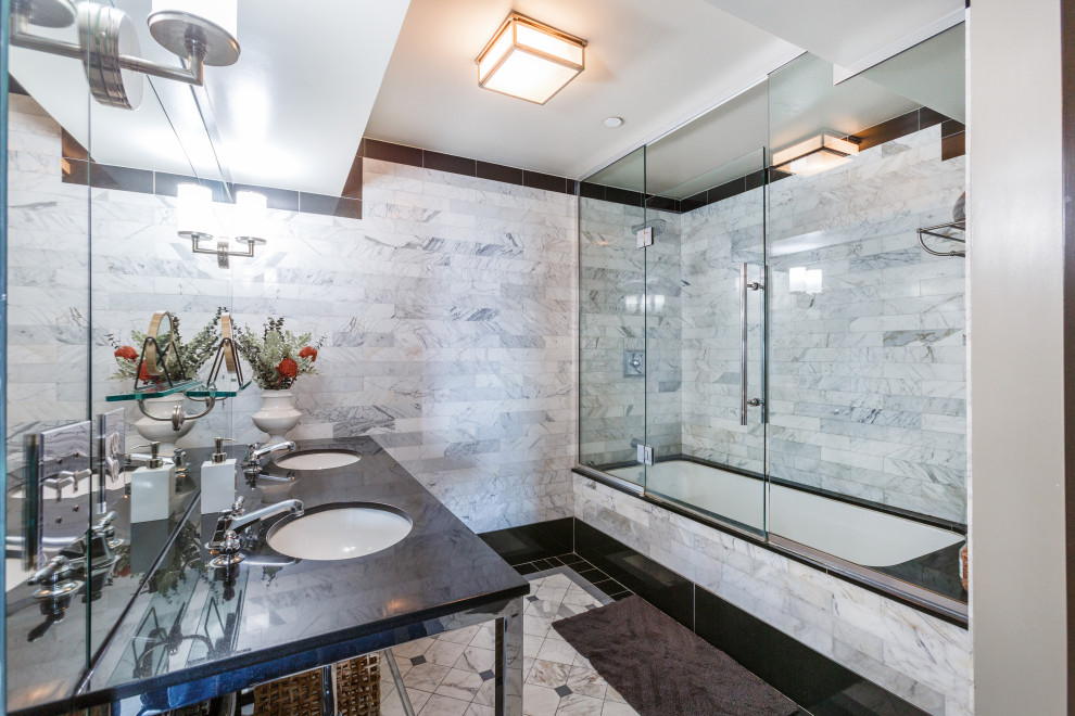 Пример оригинального дизайна: ванная комната в современном стиле с ванной в нише, душем над ванной, белой плиткой, врезной раковиной, белым полом, душем с распашными дверями, черной столешницей и тумбой под две раковины