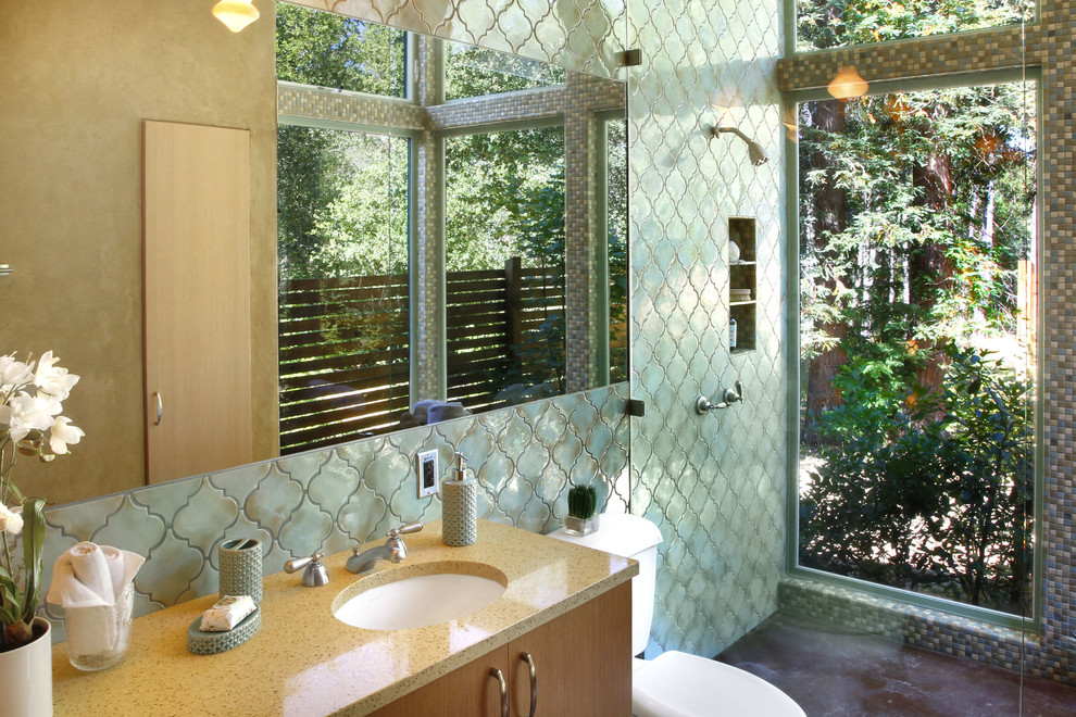 Свежая идея для дизайна: главная ванная комната в средиземноморском стиле с бетонным полом, врезной раковиной, плоскими фасадами, фасадами цвета дерева среднего тона, душем без бортиков, зеленой плиткой, зелеными стенами и окном - отличное фото интерьера