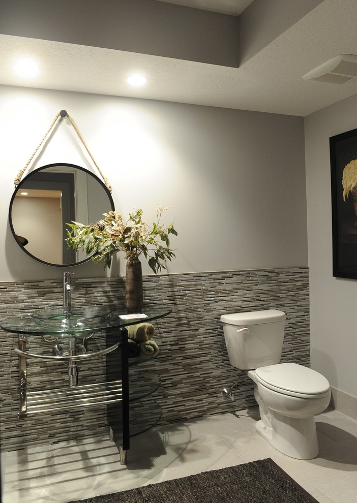 Пример оригинального дизайна: ванная комната среднего размера в современном стиле с настольной раковиной, открытыми фасадами, стеклянной столешницей, серыми стенами, раздельным унитазом, разноцветной плиткой, удлиненной плиткой и полом из керамогранита