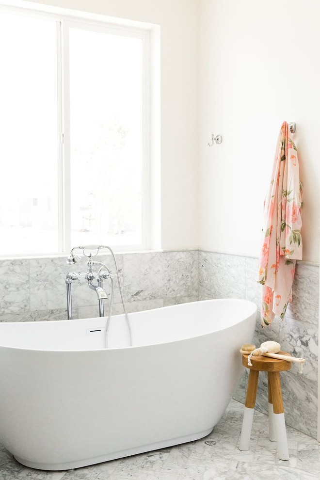 Idee per una stanza da bagno padronale chic di medie dimensioni con ante in legno bruno, vasca freestanding, piastrelle in pietra e pareti bianche