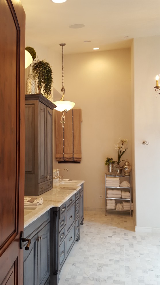 На фото: большая главная ванная комната в средиземноморском стиле с фасадами с выступающей филенкой, синими фасадами, отдельно стоящей ванной, открытым душем, унитазом-моноблоком, белой плиткой, мраморной плиткой, белыми стенами, мраморным полом, врезной раковиной, столешницей из гранита, белым полом и открытым душем