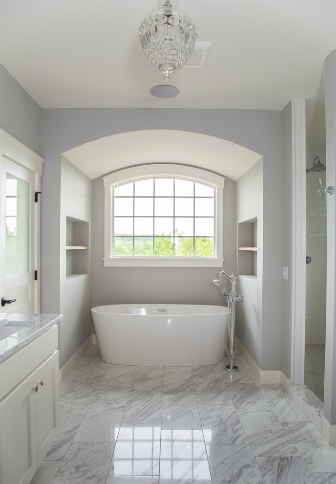 Пример оригинального дизайна: большая главная ванная комната в классическом стиле с фасадами в стиле шейкер, белыми фасадами, отдельно стоящей ванной, душем в нише, раздельным унитазом, белой плиткой, плиткой кабанчик, серыми стенами, мраморным полом, врезной раковиной, мраморной столешницей, разноцветным полом и душем с распашными дверями