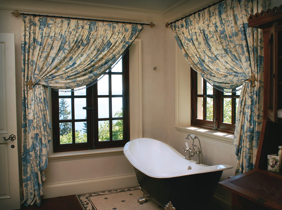 Idee per una stanza da bagno padronale tradizionale di medie dimensioni con vasca con piedi a zampa di leone, pareti grigie, parquet scuro e pavimento marrone