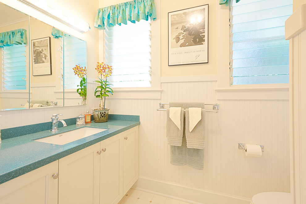 Exemple d'une salle de bain exotique de taille moyenne avec un placard à porte shaker, des portes de placard blanches, une douche d'angle, WC séparés, un carrelage blanc, un mur blanc, un sol en linoléum, un lavabo encastré et un plan de toilette en surface solide.