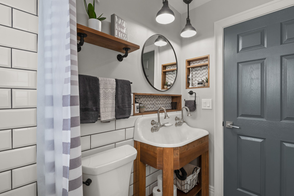 Urban bathroom in Orlando with open cabinets, medium wood cabinets, white tiles, metro tiles, grey walls, a trough sink, double sinks and a freestanding vanity unit.