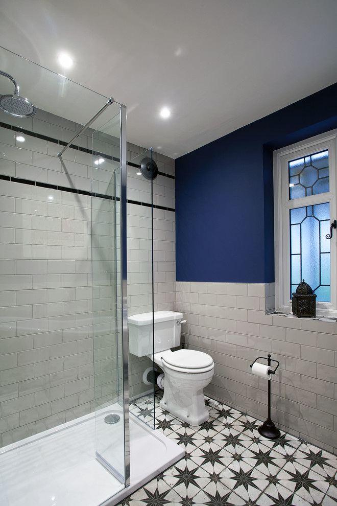 Exemple d'une salle de bain éclectique de taille moyenne pour enfant avec une baignoire indépendante, une douche ouverte, WC séparés, un carrelage blanc, des carreaux de porcelaine, un mur bleu, un sol en carrelage de céramique, un plan vasque, un sol multicolore et aucune cabine.