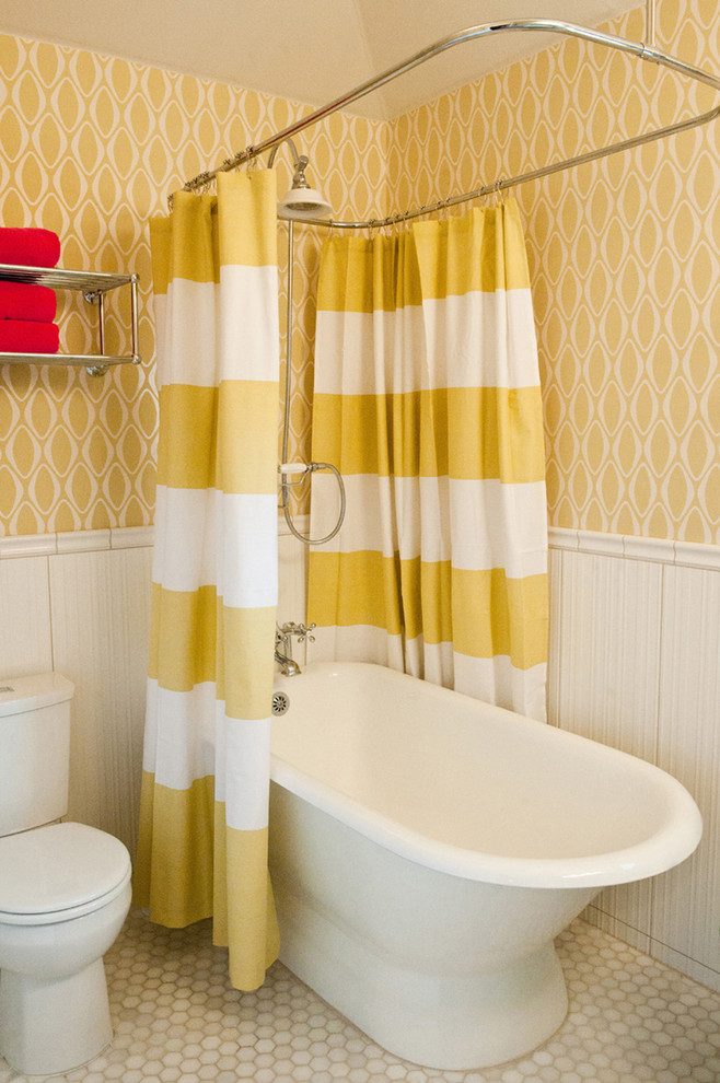 Immagine di una stanza da bagno contemporanea con vasca freestanding, WC a due pezzi e pareti gialle