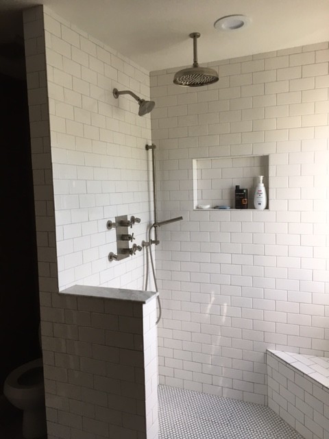 This is an example of a medium sized traditional ensuite bathroom in New York with freestanding cabinets, dark wood cabinets, a walk-in shower, a two-piece toilet, ceramic flooring, a submerged sink, an open shower, white tiles, brown walls, marble worktops and grey floors.